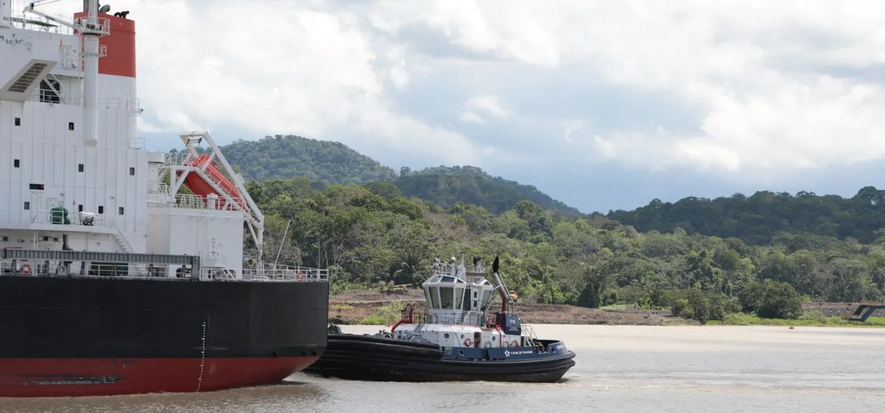 Remolcador del Canal de Panamá junto a un buque de carga