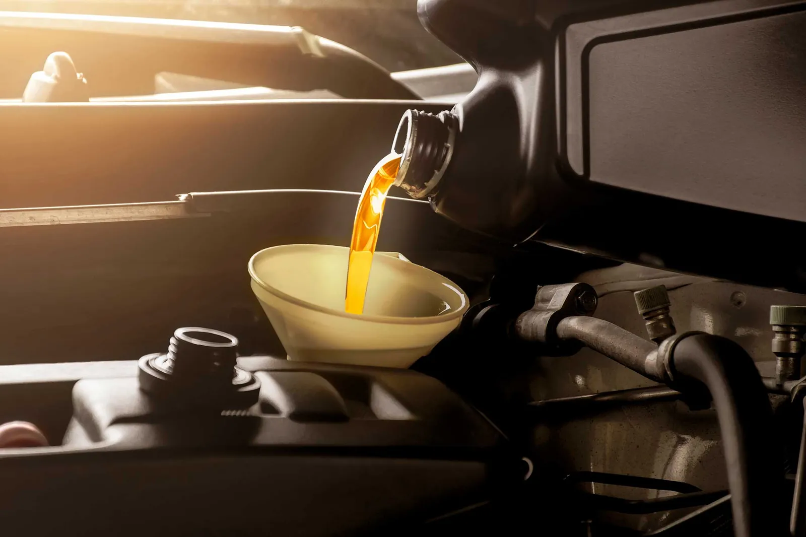Aceite lubricante vertido con un embudo en el motor de un vehículo